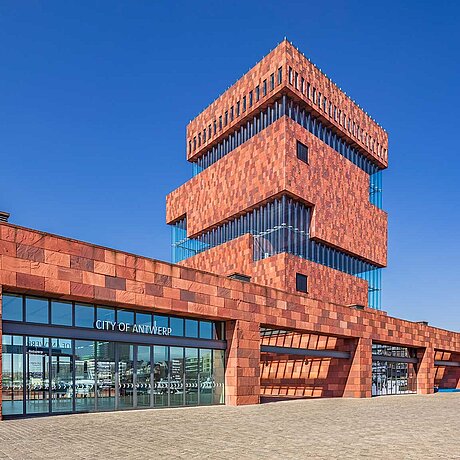 Moderní budova s fasádou z červeného kamene.